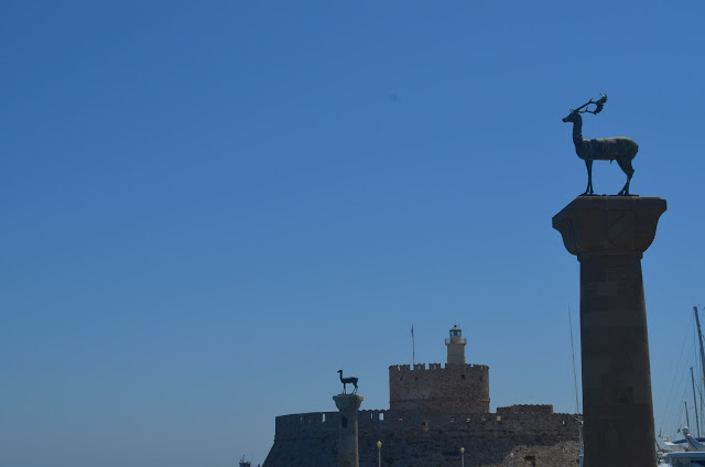 Torre com cervos no alto indicando o local do Colosso de Rodes